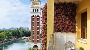 Ein Balkon mit Blick auf einen Turm, einen Fluss und eine Brücke.