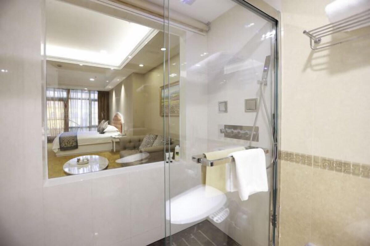 Ein modernes Badezimmer mit einer Duschkabine, einer weißen Toilette und einem Waschtisch mit ebenfalls einer Glasabdeckung.