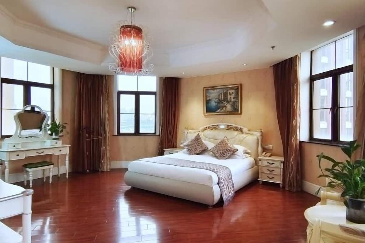 Un dormitorio amplio con una cama grande, un escritorio y una silla.