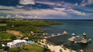 A coastal resort with a swimming pool, a dock, and a beach area.