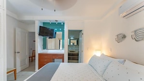 Ein Schlafzimmer mit Bett, Schminktisch, Fernseher und Kleiderschrank.