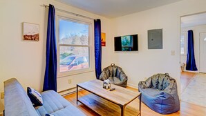 A modern living room with a sofa, two bean bags, a coffee table, and a TV on the wall. - Poconos Mountain View Cottage Near Skiing, Hiking   NO CLEANING FEE! (Sciota)