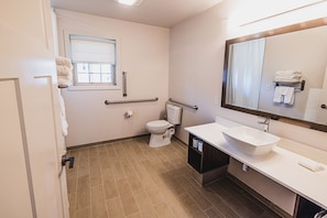 A modern bathroom with a toilet, bidet, and sink, equipped with grab bars and a window for natural light. - Frosty Valley Resort (Danville)