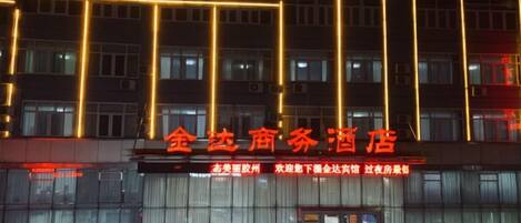 A hotel with a modern facade and illuminated signage.