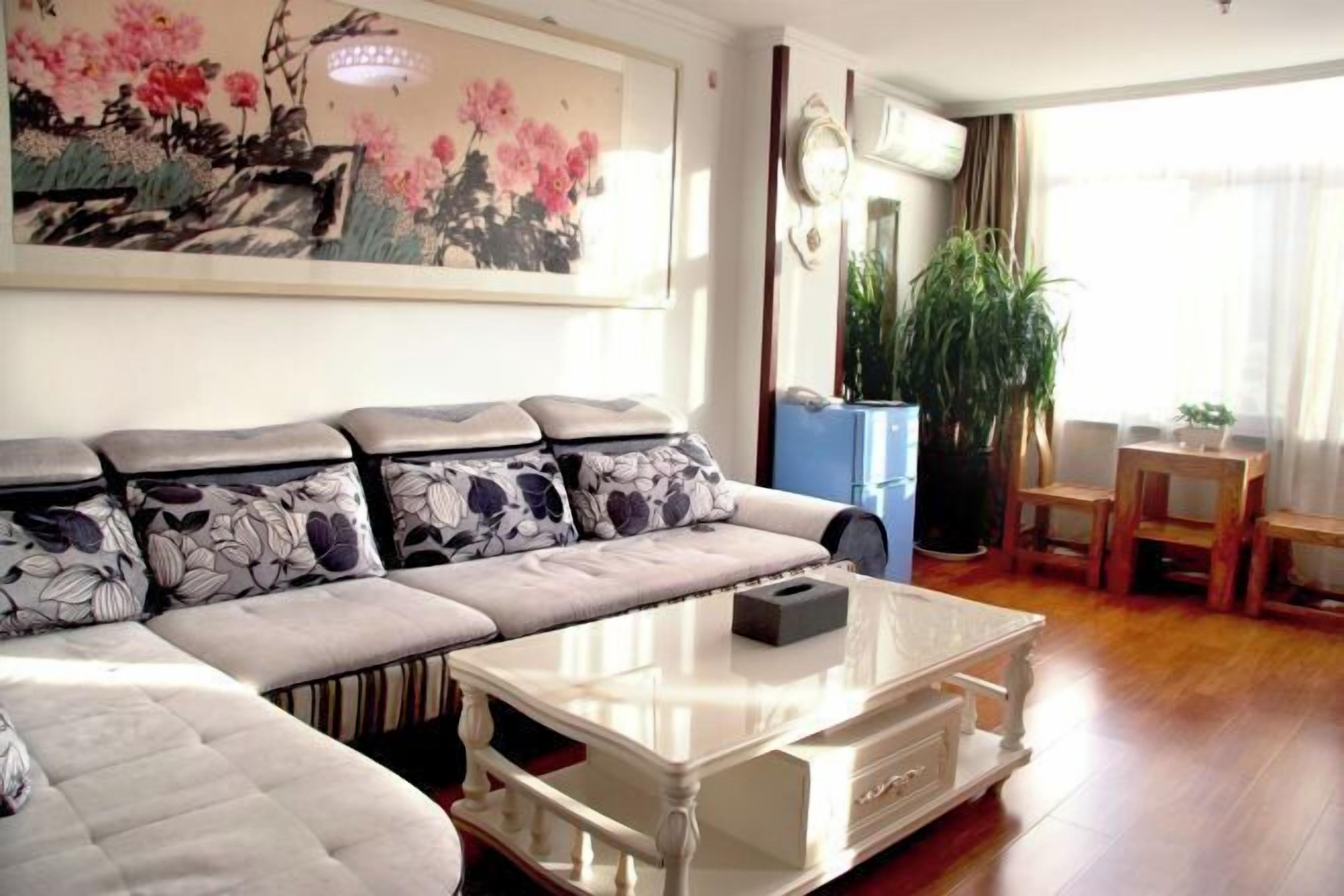 A living room with a sofa, a coffee table, and a painting on the wall.