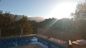 Una piscina con vistas a montañas al fondo.