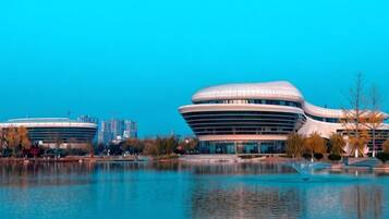 A modern building with a unique curved architecture by the water.