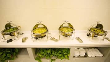 A buffet setup with three bowls of food, a set of condiment containers, and a row of napkins.