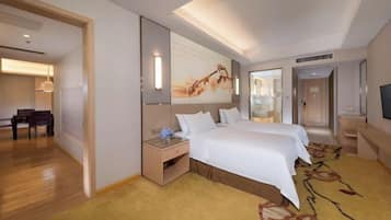 A hotel room with a large bed, a desk with a chair, a flat-screen TV, and a large window.