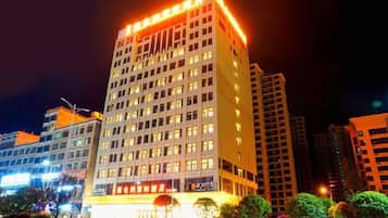 A multi-story hotel with a prominent entrance and illuminated signage.