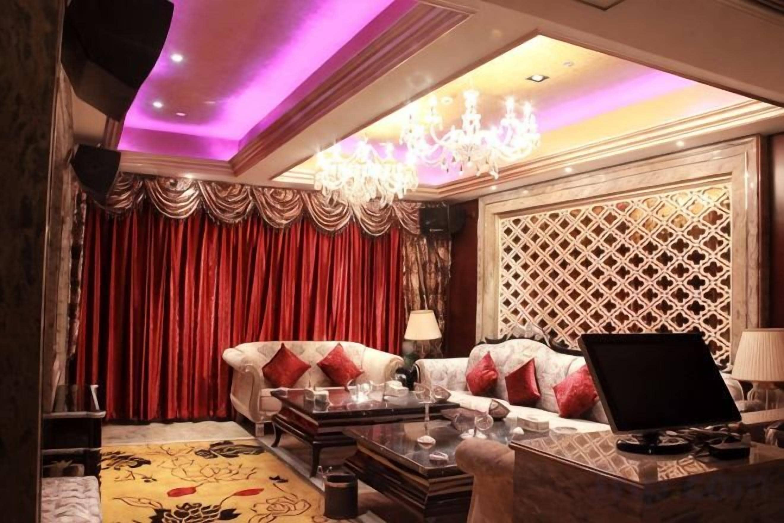 A luxurious living room with a sofa, a coffee table, and a chandelier.