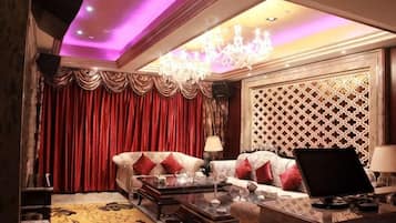 A luxurious living room with a sofa, a coffee table, and a chandelier.