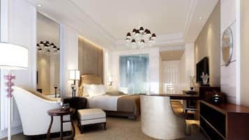 A hotel room with a bed, a sitting area, a desk, and a large mirror.