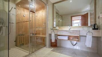 Une salle de bain moderne avec une douche à parois de verre, un grand miroir et un comptoir en marbre.