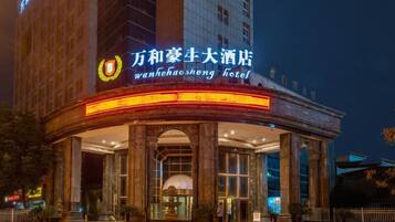 A hotel with a prominent sign, large columns, and a covered entrance.
