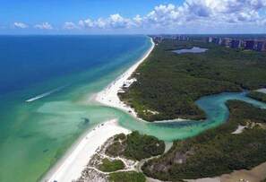 An aerial view of a coastal area with a beach, clear waters, and surrounding greenery. - 1 Mile to Beach! Pool, King Bed, BBQ, Games (Naples)