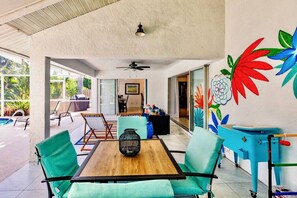 A modern interior with a wooden table, teal chairs, and a colorful mural.