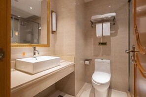 Ein modernes Badezimmer mit einem weißen Waschbecken, einer Toilette und einer Duschkabine aus Glas.