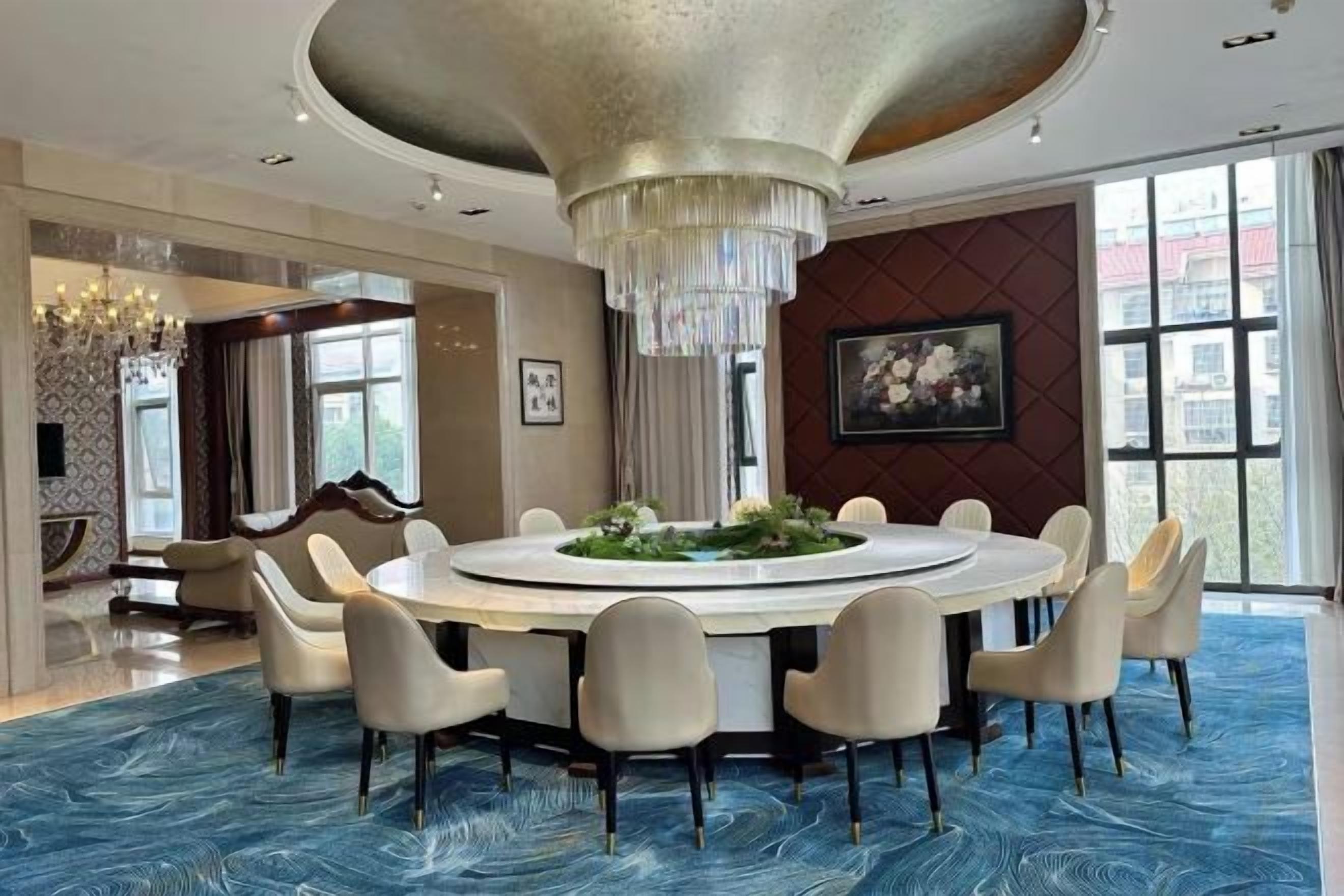 A circular dining area with a chandelier, round table, and chairs.