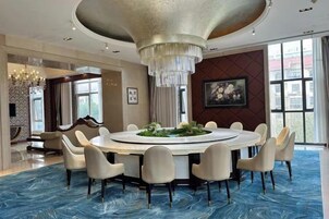 Un comedor circular con candelabro, mesa redonda y sillas.