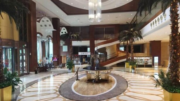 A spacious lobby with a central fountain, palm trees, and a modern staircase. - Ruixiang International Hotel (Quanjiao)
