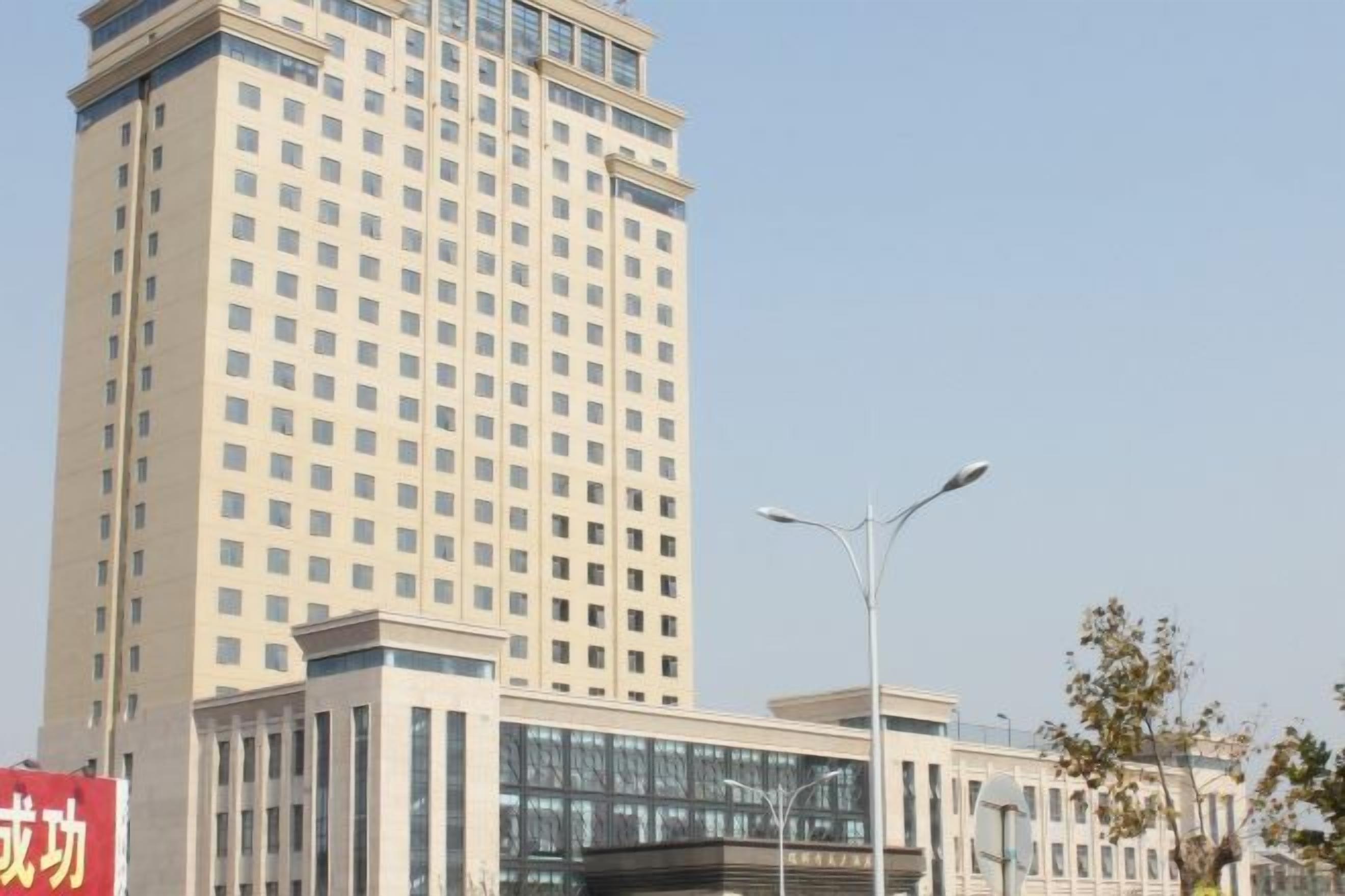A tall building with a modern design, featuring a large glass facade and a structured, grid-like pattern of windows.