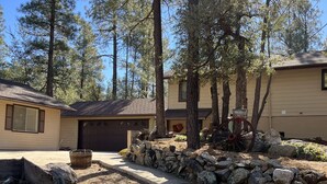 A residential area with two houses, a stone wall, and a wooden bench. - 3 Room Cozy Suite in the Pines, near Downtown Prescott & many other attractions (Prescott)