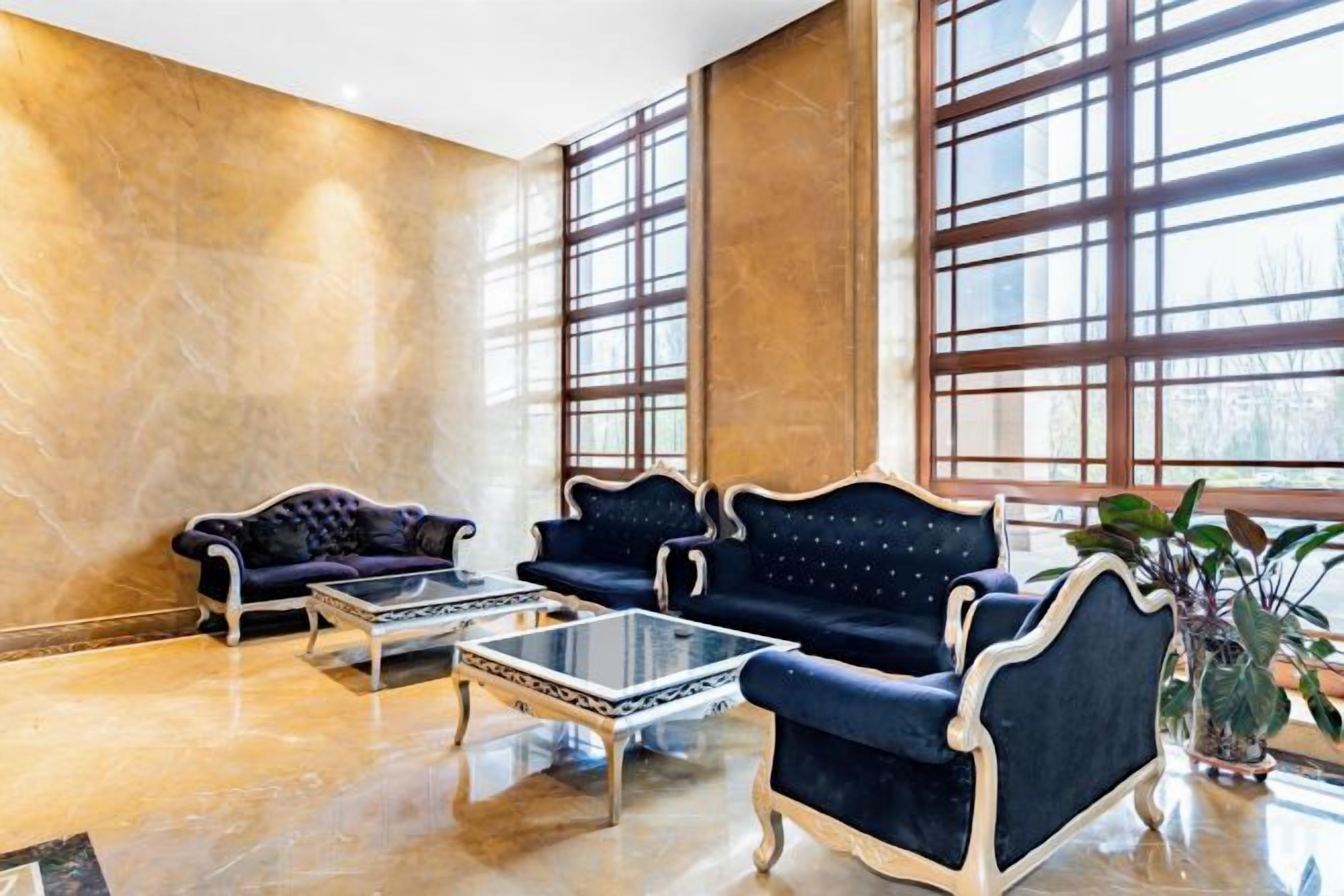 A lobby with two sofas, a coffee table, and a potted plant.