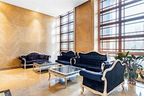 A lobby with two sofas, a coffee table, and a potted plant. - Triumphal Gate Holiday Hotel (Toketo No.1 Middle School) (Togtoh County)