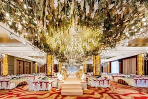 A banquet hall with a central aisle, round tables, and a chandelier. - Triumphal Gate Holiday Hotel (Toketo No.1 Middle School) (Togtoh County)