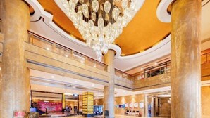 Un hall espacioso con una gran lámpara de araña, varios pisos y un diseño arquitectónico moderno.