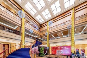 A multi-level atrium with a central staircase, glass ceiling, and decorative elements. - Triumphal Gate Holiday Hotel (Toketo No.1 Middle School) (Togtoh County)