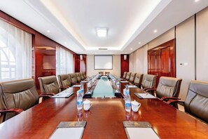 A conference room with a long table, multiple chairs, and a projector screen. - Triumphal Gate Holiday Hotel (Toketo No.1 Middle School) (Togtoh County)