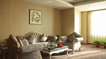 Una sala de estar con sofá, sillones, una mesa de centro y un cuadro en la pared.