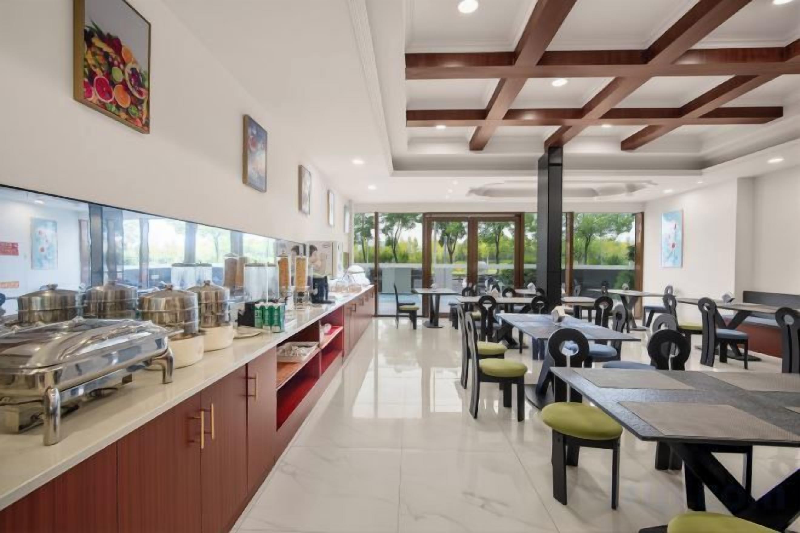 Un comedor moderno con un mostrador tipo bufé, varias mesas y sillas.