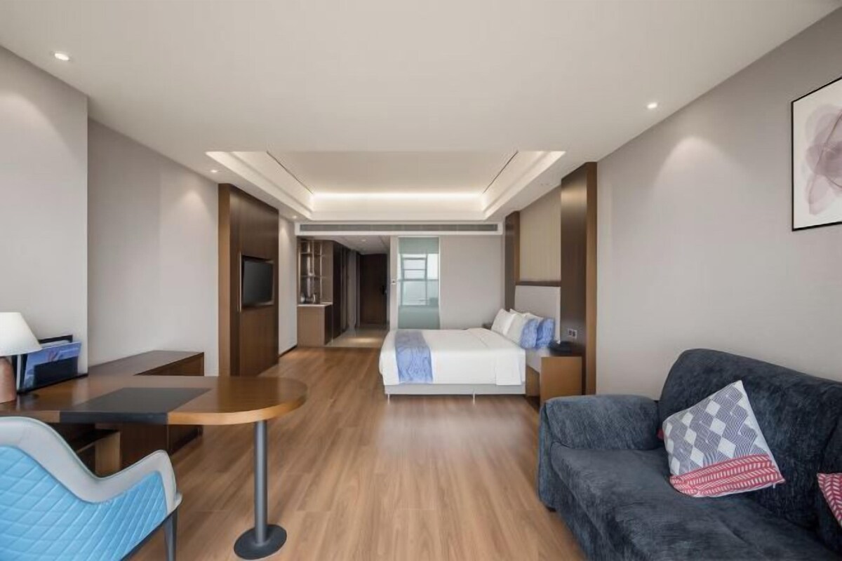 Een hotelkamer met een bed, een bank, een bureau en een televisie.