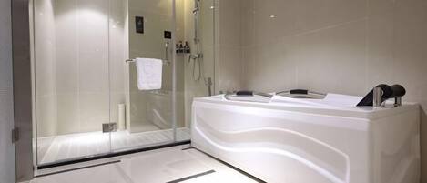 A modern bathroom with a glass-enclosed shower, a large white bathtub, and a sleek vanity.