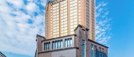 Un hotel de varios pisos con un letrero llamativo y una fachada moderna.