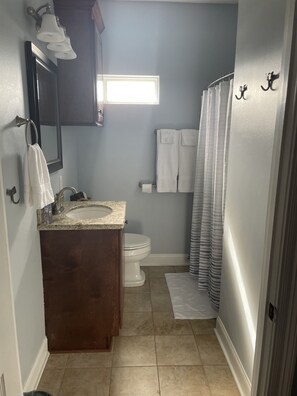 A bathroom with a sink, toilet, and shower curtain.