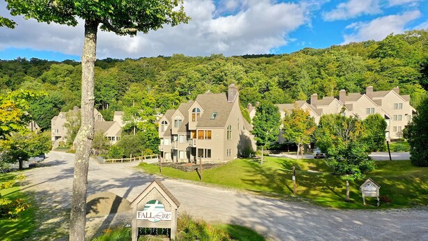 A residential area with multiple houses, a sign for 'FALL LINE', and a well-maintained lawn. - Fall Line Small Studio - Perfect for Two - On Shuttle Route w/ Amenities B4A (Killington)