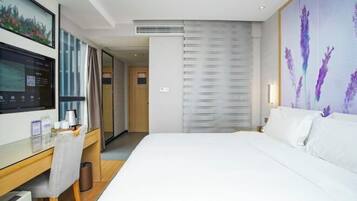 A hotel room with a bed, a desk with a chair, a TV, and a large window.