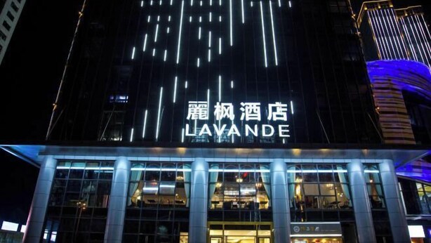 Un hotel con fachada moderna, señalización iluminada y entrada de vidrio.