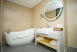 A modern bathroom with a freestanding bathtub, a vanity with a mirror, and a towel shelf. - Lavande Hotels (Xianning Tonghui Square) (Xianning)