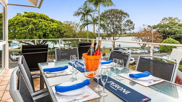 A table set for dining with a view of a parking area and trees. - Regatta Noosa - Top Floor Magic Views (Noosaville)