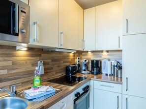 A modern kitchen with a built-in oven, a coffee maker, and a toaster. - Ferienwohnung Südstrand - Keine 5 Minuten vom Strand Entfernt (Wyk auf Föhr)