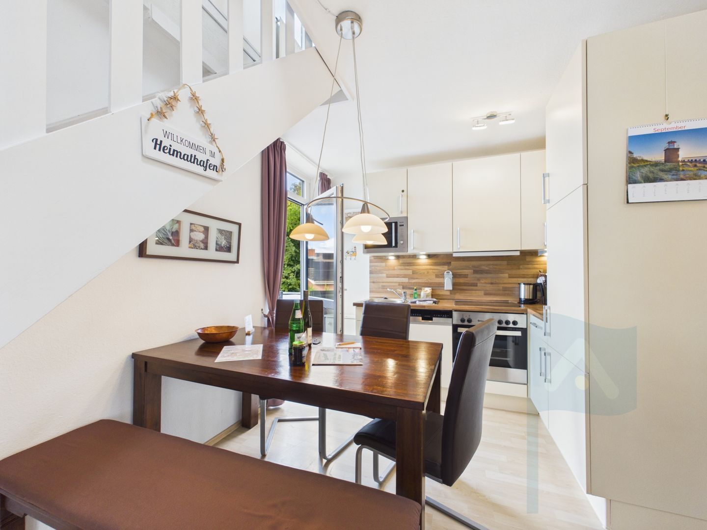 A modern kitchen with white cabinets, a wooden countertop, and stainless steel appliances.