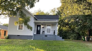 A single-story house with a front porch, a small front yard, and a tree to the left. - Private oasis (Charlotte)