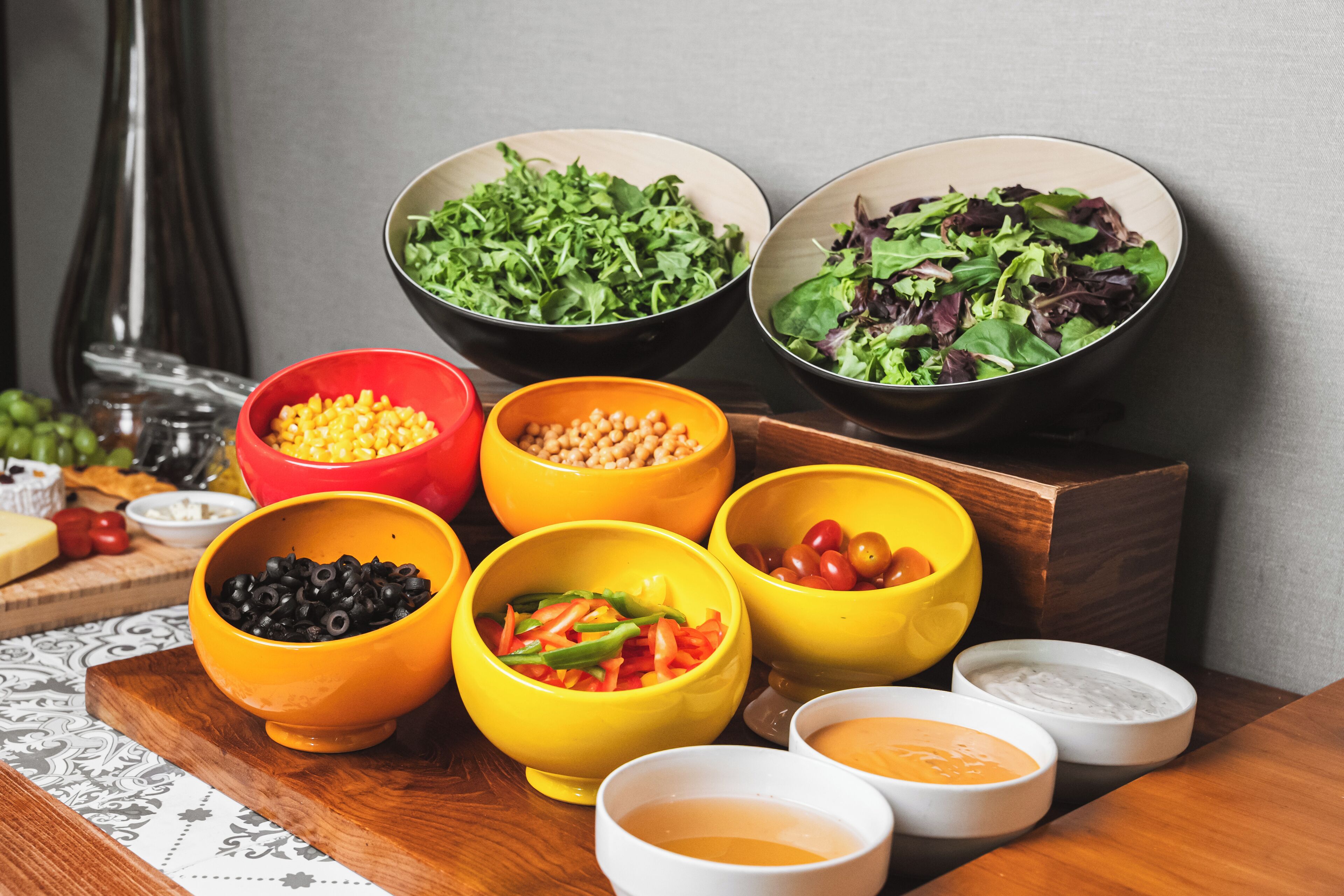 A variety of bowls containing different food items and condiments on a wooden table.