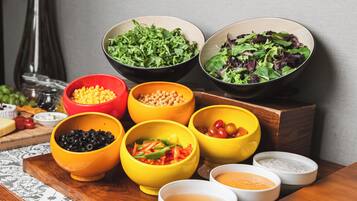 A variety of bowls containing different food items and condiments on a wooden table.
