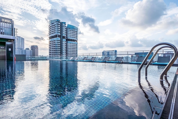 Una piscina al aire libre, tumbonas